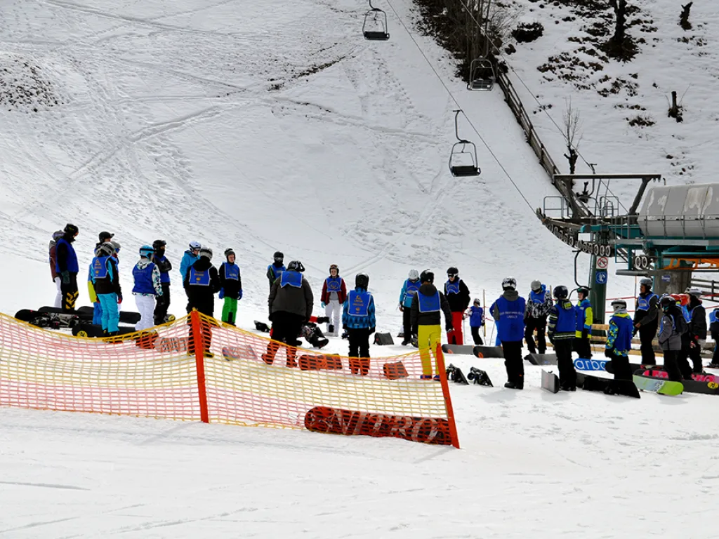 Gruppe steht in einer Reihe hinter dem orangefarbenen Absperrnetz.